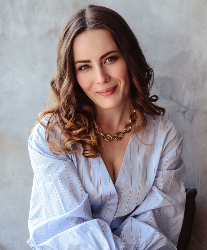 Smiling woman wearing a blue striped blouse.
