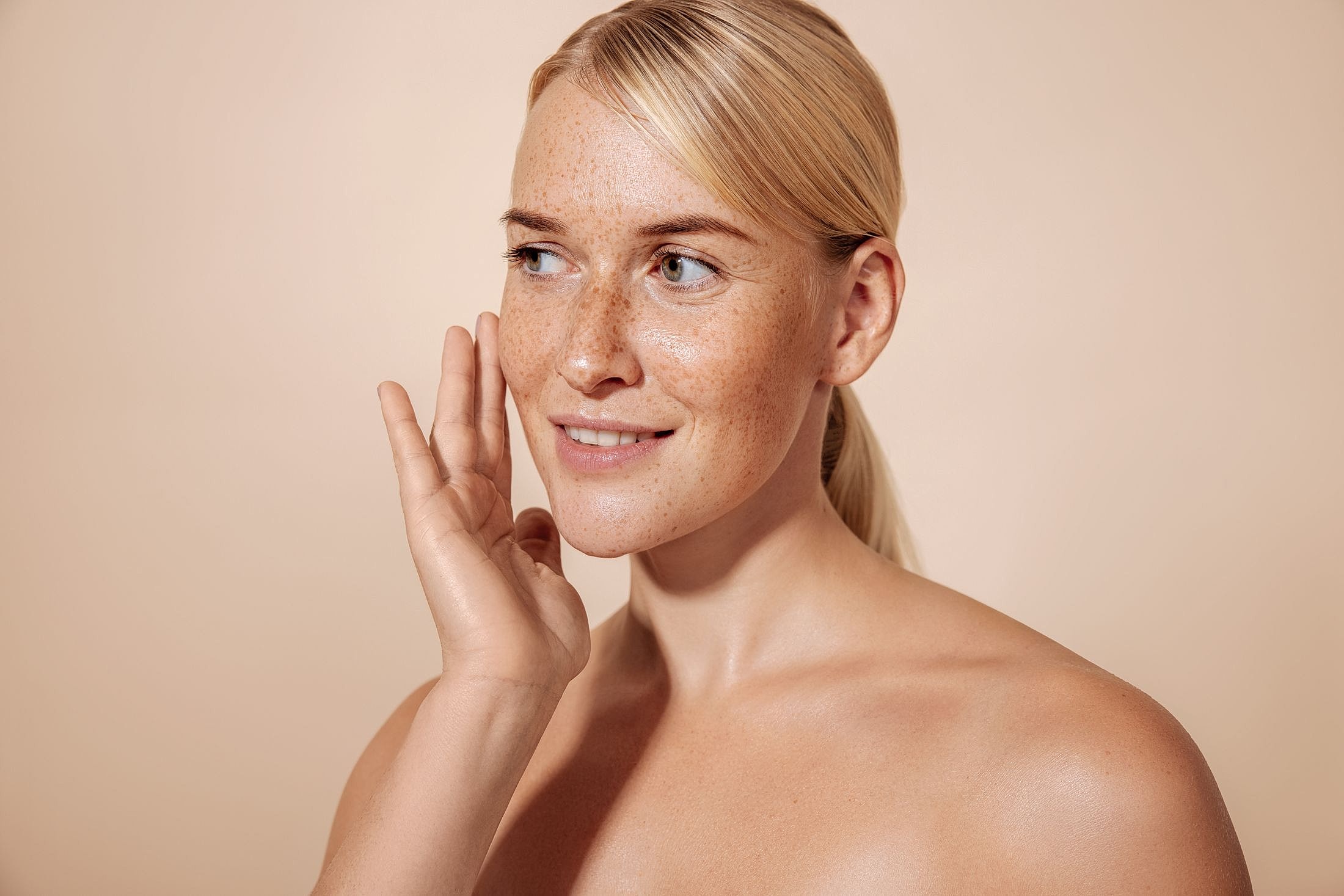 Smiling woman with freckles and smooth skin.